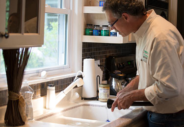 A home inspector checking the kitchen plumbing.